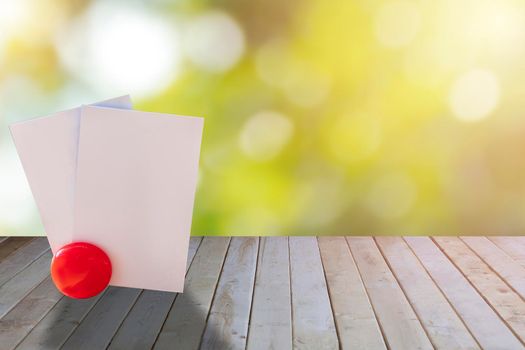 Empty white papers card on wood table with green bokeh background. Empty name card paper on wooden use for text or design. with copy space