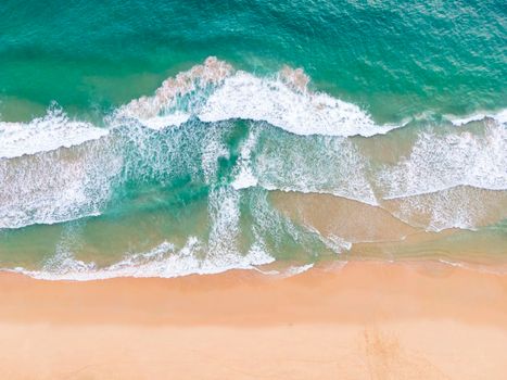 Aerial view top view Beautiful topical beach with white sand coconut palm trees and sea. Top view empty and clean beach. Waves crashing empty beach from above. With copy space.