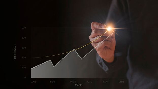 Businessman hand drawing chart graph stock of growth. Hand man uses pen to draw stock graph chart point of target success. Business concept.