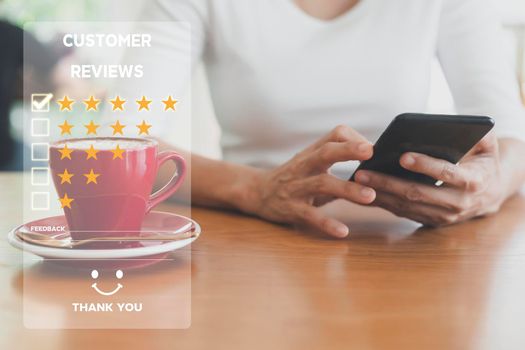 Customer service and Satisfaction concept ,Women hand hold smart phone empty screen choose the 5 star icon to give satisfaction in service. rating very impressed in coffeeshop.