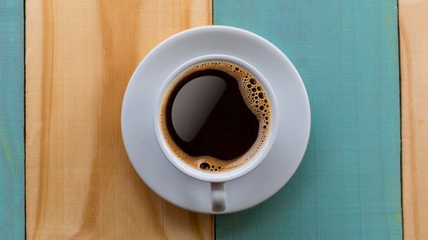 Coffee Mug on Wooden Table. Top view cup of coffee on wooden table. Close up hot coffe in white cup on wood table.