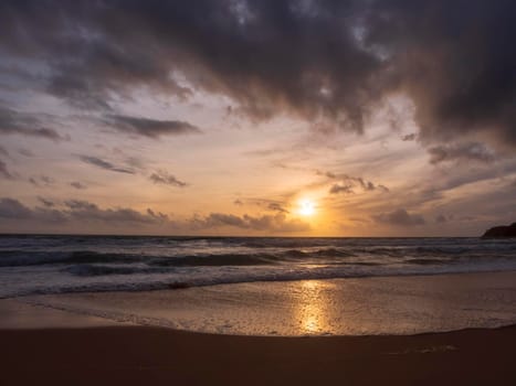 Beautiful sunset over the clam sea with cloud sky background. Sunset over tropical beach. Nature summer  concept. Peak sunset over sea with yellow light reflect on sea water. Tranquil seascape. Horizon over the water.