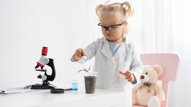 front view cute toddler learning about science with plant microscope