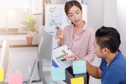 Asian small business start up working at Private Home Office social distancing among Coronavirus outbreak. Business people show and talking about document chart financial report. 