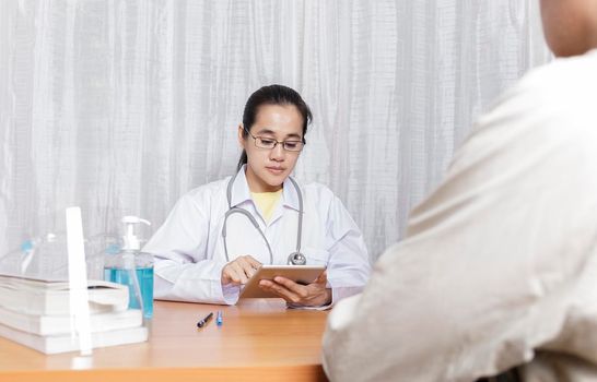 Doctor working in her clinic and listening and analysis to the patient, Doctor analysis tablet and listening explaining his symptoms. healtcare and assistance concept
