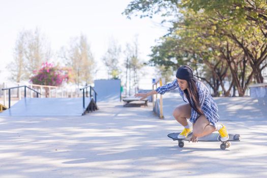 Young asian women play surf skate board at park skate ramp outdoors on morning. Happy women play surfskate board at park . Sport activity lifestyle concept