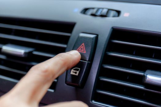 Close up hand press the emergency light in the car, Fingers press button.for open the contract emergency light in car. Emergency button press for open emergency light warning sign symbol out side car