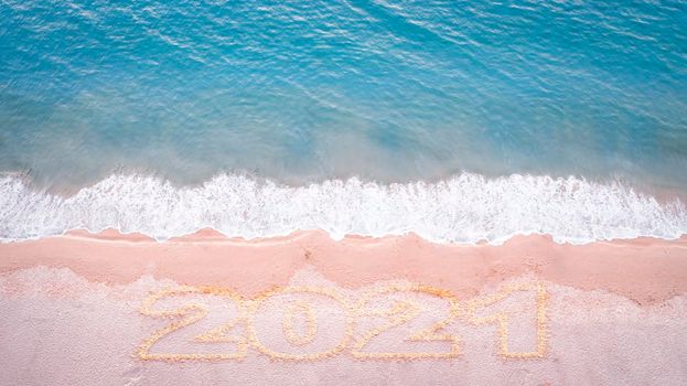 Aerial drone top view happy new year 2021 written on sandy beach sea with copy space. New year concept