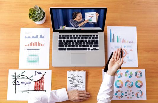 Top view Businessman and businesswoman analysis financial chart with videoconference online meeting. Hand of businesswomen using laptop meeting with diverse colleagues. Covid-19 working from home. 