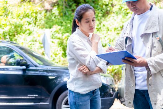 Car accident Car crash The woman talking to  Insurance agent about the accident. Insurance agent writing document on clipboard of the incident for claim process. Transportation concept.