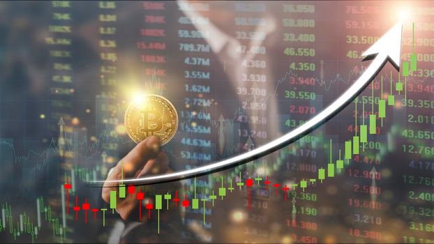 Hands of businessman with gold bitcoin coin. Volatile business graph on global network, Financial, Stock market, Cryptocurrency and investment. Stock market graph up. New Virtual money concept
