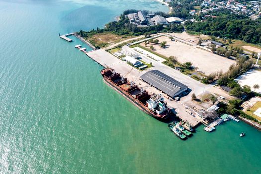 Aerial drone top view of containers cargo ship at industrial import-export port. Business logistic import and export freight transportation by container ship in open sea