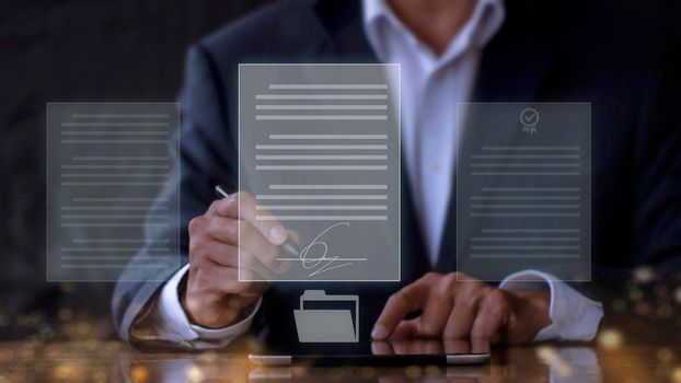 businessman use electronic pen sign signature on electronic  E-signing, data sheet document management, paperless office concept. Businessman using stylus pen signing e document on digital tablet.