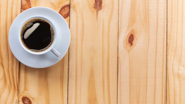 Coffee Mug on Wooden Table. Top view cup of coffee on wooden table. Close up hot coffe in white cup on wood table.