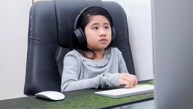 Asian girls study online with laptops. Kid wear headset typing keyboard notebook learning using internet lessons on quarantine. Students learn with internet online class from school Covid-19