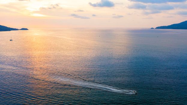 Drone view. Holiday at tropical sea with sunset sky. Beautiful sunset over the sea with cloud sky background. Sunset over tropical beach. Nature summer holiday travel concept. Tropical sea with boat and jet ski
