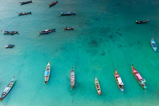 Aerial drone top down view of fishing boats in the shore during low tide. Top view a lot of Thai traditional longtail fishing boats in the tropical sea. A lot of long tail boat on sea
