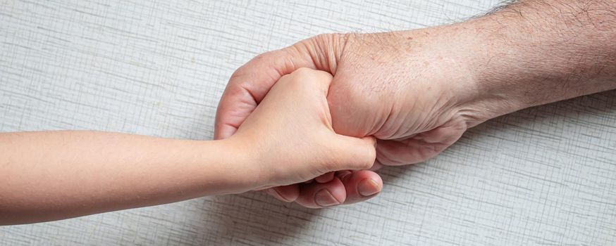 old man holding child's hands. selective focus people