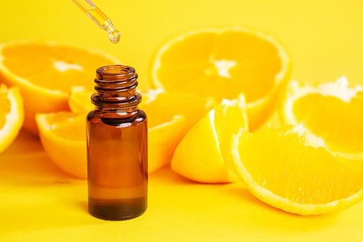 orange essential oil on a yellow background. Selective focus.nature