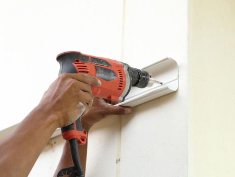 worker using drill to attach panel to wall