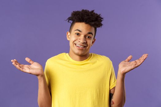 No big deal. Close-up portrait of carefree, unbothered friendly-looking young man enjoying weekends, have no worries, cant tell anything, being clueless and unaware, shrugging with sorry smile.