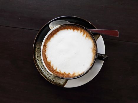 cup of hot coffee with cream on table