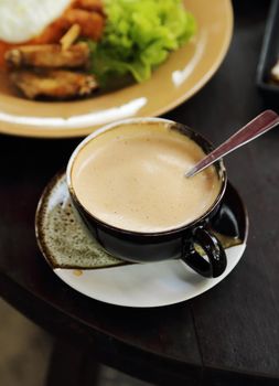 cup of hot coffee with cream on table