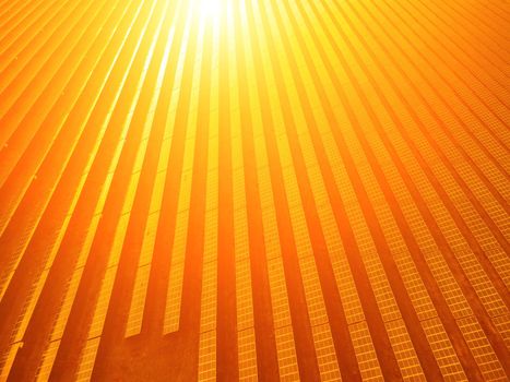 Aerial top view of a solar panels power plant. Photovoltaic solar panels at sunrise and sunset in countryside from above. Modern technology, climate care, earth saving, renewable energy concept