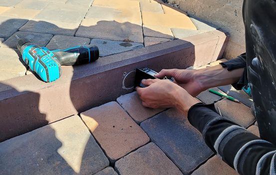 drilling a concrete curb to install the luminaire. Selective focus