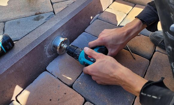 drilling a concrete curb to install the luminaire. Selective focus