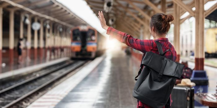 Pretty Young traveler woman planning trip at train station. Summer and travel lifestyle concept