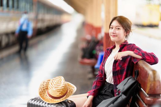 Young traveler woman looking for friend planning trip at train station. Summer and travel lifestyle concept