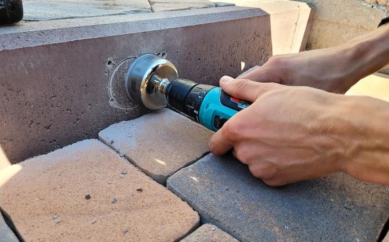 drilling a concrete curb to install the luminaire. Selective focus