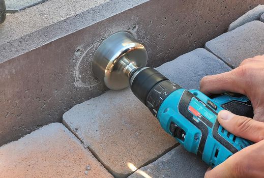 drilling a concrete curb to install the luminaire. Selective focus