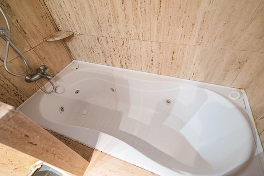 Empty and old jacuzzi bath tube in bathroom interior of a flat.