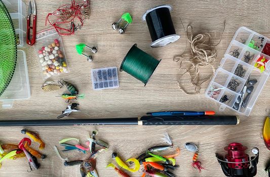 Fishing tackle. Float, wobbler, bait hooks, on a wooden background. Selective focus