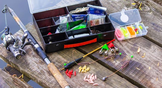 many colorful lures for fishing on the wooden pier. Selective focus. nature