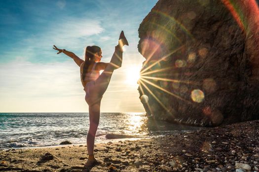 Girl gymnast is training on the beach by the sea sunset. Does twine. Photo series