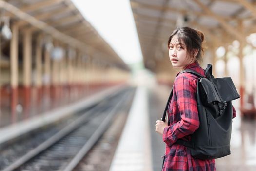 Young traveler woman looking for friend planning trip at train station. Summer and travel lifestyle concept