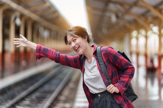 Pretty Young traveler woman excite and planning trip at train station. Summer and travel lifestyle concept