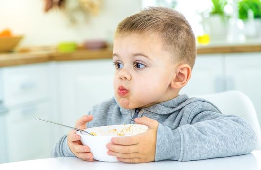 children in the kitchen at the table turning pasta. selective focus