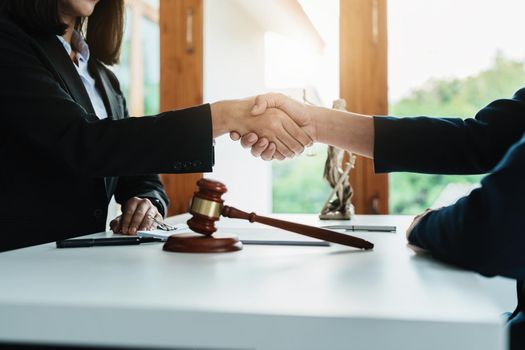 Law, consultation, agreement, contract, lawyer or attorney shakes hands to agree on the client's offer to be hired to fight the parties in court