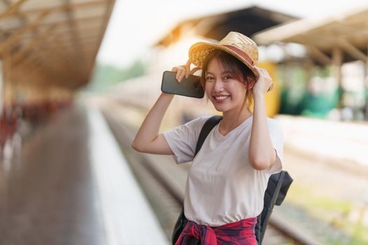 Pretty Young traveler woman excite and planning trip at train station. Summer and travel lifestyle concept