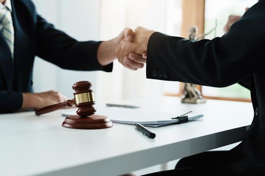 Law, consultation, agreement, contract, lawyer or attorney shakes hands to agree on the client's offer to be hired to fight the parties in court