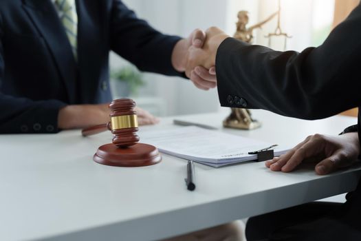 Law, consultation, agreement, contract, lawyer or attorney shakes hands to agree on the client's offer to be hired to fight the parties in court