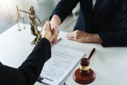 Law, consultation, agreement, contract, lawyer or attorney shakes hands to agree on the client's offer to be hired to fight the parties in court