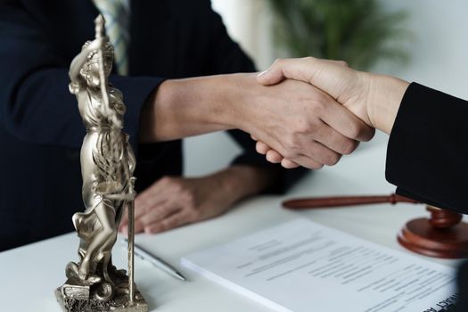 Law, consultation, agreement, contract, lawyer or attorney shakes hands to agree on the client's offer to be hired to fight the parties in court