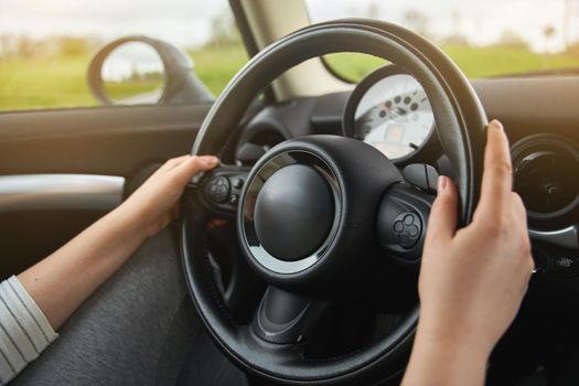 Young girl holding a steering wheel. A girl drives a car.