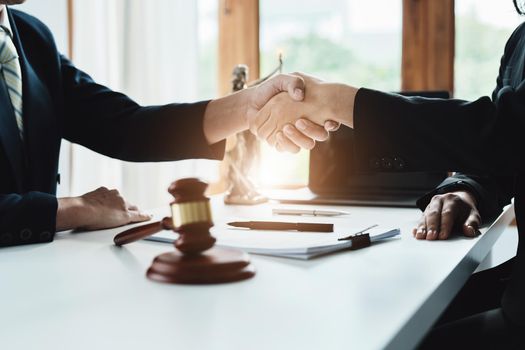 Law, consultation, agreement, contract, lawyer or attorney shakes hands to agree on the client's offer to be hired to fight the parties in court