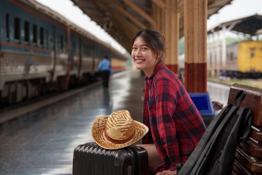 Young traveler woman looking for friend planning trip at train station. Summer and travel lifestyle concept.